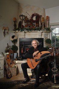 John Doan Victorian Christmas Concert with harp guitar in front of fire place.
